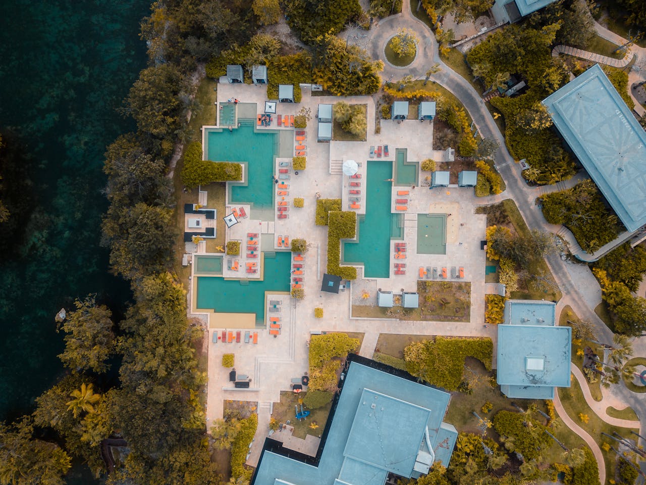 Explore the stunning aerial view of a luxury resort in Playa del Carmen, Mexico, showcasing pools and lush greenery.